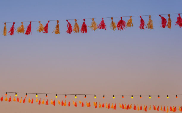 红色和黄色的花环和天空背景上的照明。图片下载