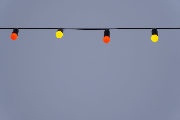 红色和黄色的花环和天空背景上的照明。圣诞背景与拷贝空间。图片下载