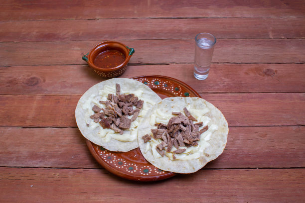 烤牛肉玉米饼配瓦哈卡奶酪、红酱和少量龙舌兰酒或梅斯卡尔。墨西哥食物图片下载