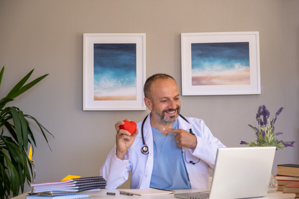 远程医疗。高级医生坐在家庭办公室用笔记本电脑与患者进行在线视频咨询。图片下载