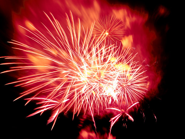 红黄色的烟花在点燃的烟雾和黑色的天空背景图片下载