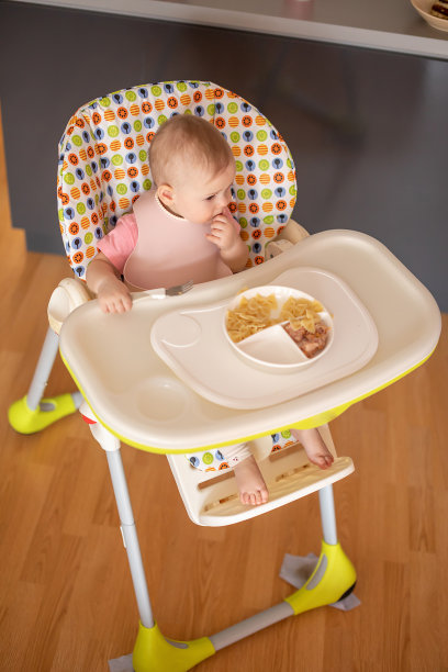 一岁女孩在婴儿餐椅上均衡饮食，为孩子提供健康均衡的营养图片下载