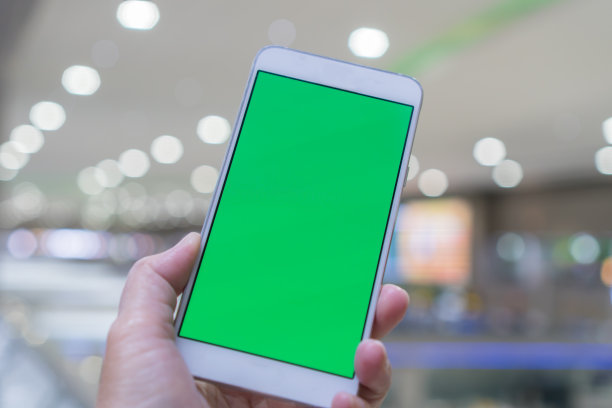 绿色空白屏幕模拟手机广告。数字智能手机持有移动信息互联网在任何地方在模糊的背景。新一代技术物联网图片下载