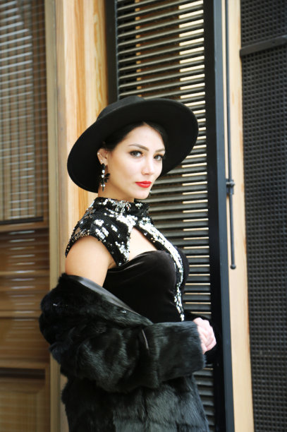 穿着皮草大衣戴着帽子的漂亮年轻女人图片下载