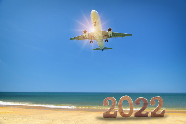2022年新年和商用飞机在热带海滩和蓝天的背景下图片下载