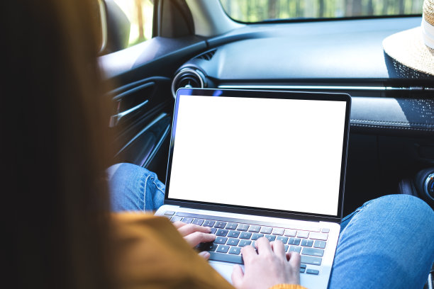 一位女士在车里用笔记本电脑打字，屏幕是空白的图片下载