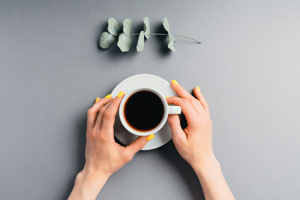 一个女人的手拿着一杯茶图片下载