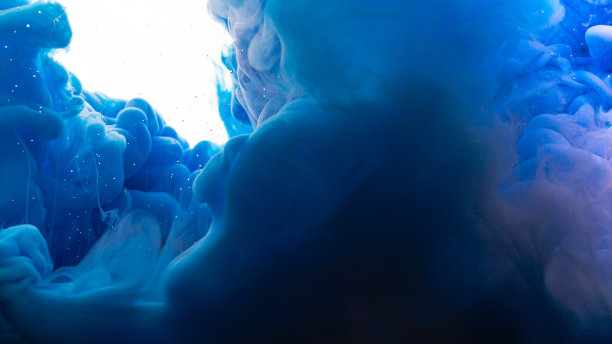 墨水滴在水里。抽象的背景。蓝色背景。图片下载