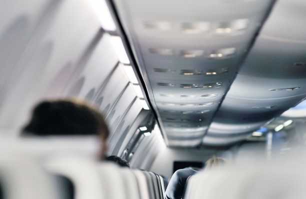 在飞机上系好安全带和禁止吸烟标志，飞机上空调的顶控台上。飞机上的标志。图片下载