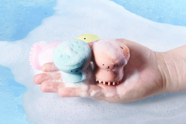 硅胶按摩刷在女性手掌上覆盖泡沫。清洁和新鲜，个人卫生的概念图片下载