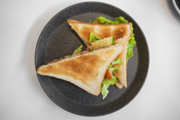 三文鱼三明治配全麦面包，配沙拉，黄瓜，洋葱，放在深色盘子里。正确营养的概念，早餐-烤鲑鱼。图片下载