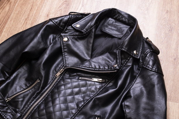 木制背景上的黑色皮夹克图片下载