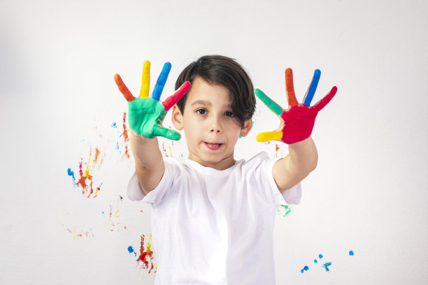 男孩在他的手上展示彩色的颜料图片下载