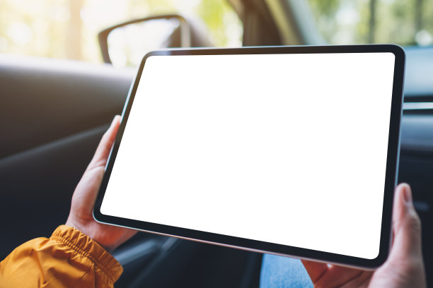 一个女人在车里拿着并使用着黑屏的平板电脑图片下载