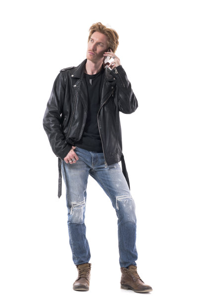 体贴英俊的摩托车风格的年轻男子在电话中看向别处图片下载