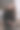 身穿黑色皮夹克的年轻女子微笑着站在白墙前，靠在铁栏杆上，看着摄像机。都市风格与街头时尚。穿着休闲装的卷发女孩图片下载