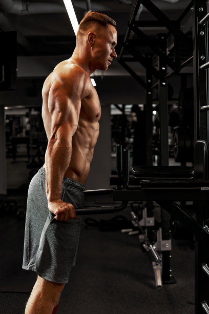 男子一名运动员正忙着在体育馆里锻炼手臂上的二头肌黑色背景。高质量的照片图片下载