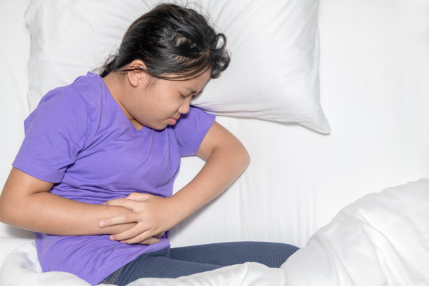 亚洲儿童胃痛，躺在床上。腹泻或健康图片下载