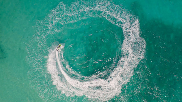 航拍水上摩托艇在碧绿海水中行驶图片下载