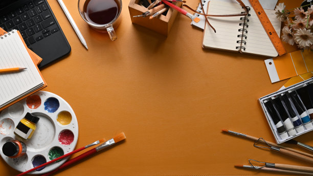 艺术家的工作空间与画笔，调色板，水彩和笔记本上的黄色皮革。图片下载