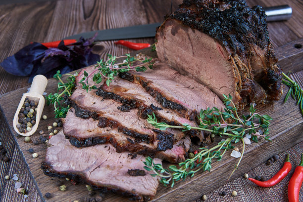 砧板上的烤牛肉。木制背景。图片下载