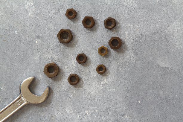 石材背景上的扳手螺母和螺栓图片下载