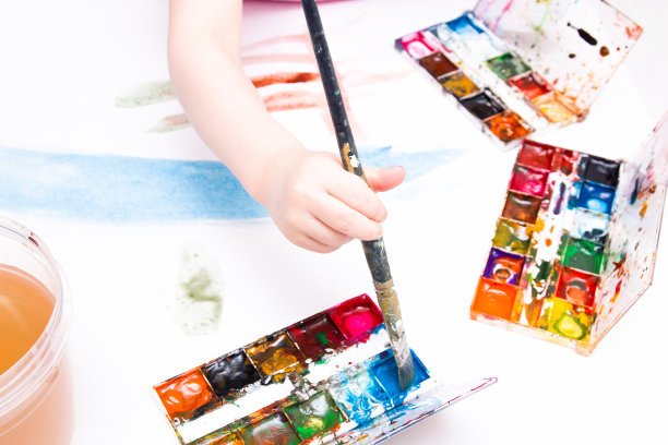 孩子用水彩笔在一张白纸、一张桌子、一个复印处画画图片下载