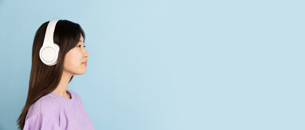 蓝色画室背景上的亚洲年轻女子肖像。人的情感、面部表情、青春、销售、广告的概念。图片下载