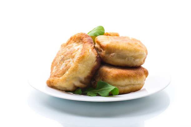 煎派和肉放在盘子里，放在白盘上图片下载