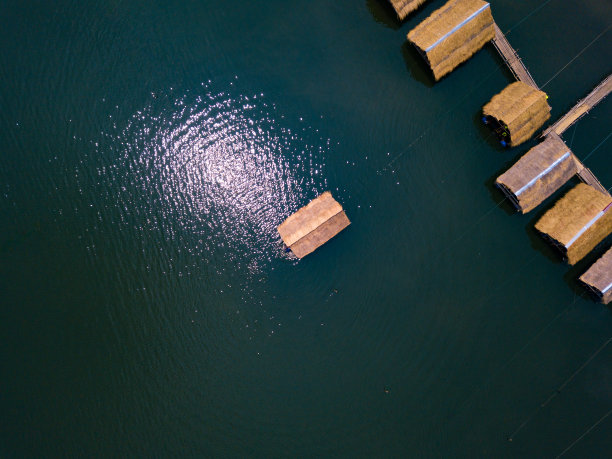 湖面上竹筏村舍，阳光倒映水面图片下载
