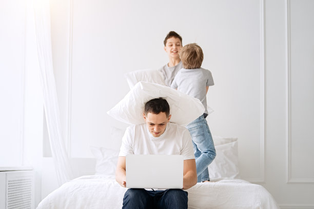 父亲工作与孩子和笔记本电脑在家里图片下载