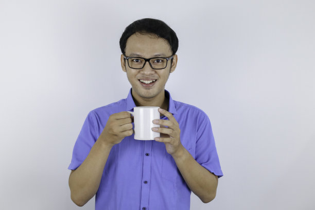 年轻的亚洲男子是微笑，并带来白色的咖啡享受它在早上图片下载