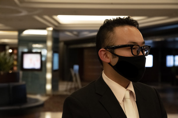 穿着黑色西装站在酒店接待处的保安图片下载