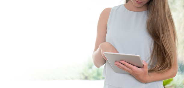 横幅与复制空间随意年轻白种人与长发使用平板。女孩手里拿着垫子。图片下载