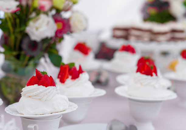 小婚礼蛋糕上草莓和花在背景。图片下载