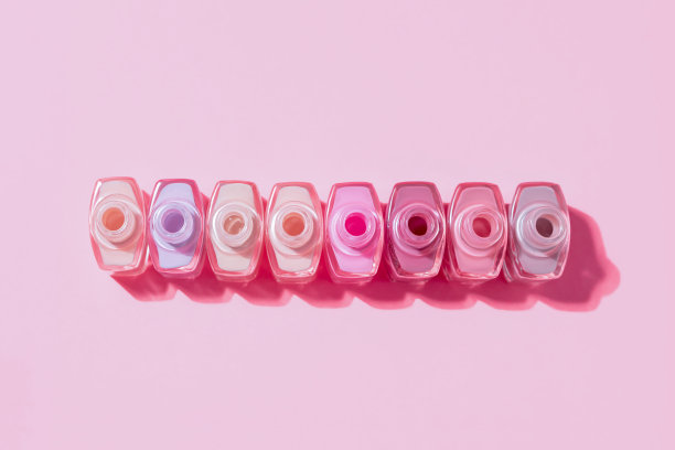 一套指甲油瓶子。一组指甲油孤立在紫色背景上。副本的空间。图片下载