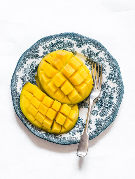 新鲜成熟的芒果切片在一个轻的背景，俯视图图片下载