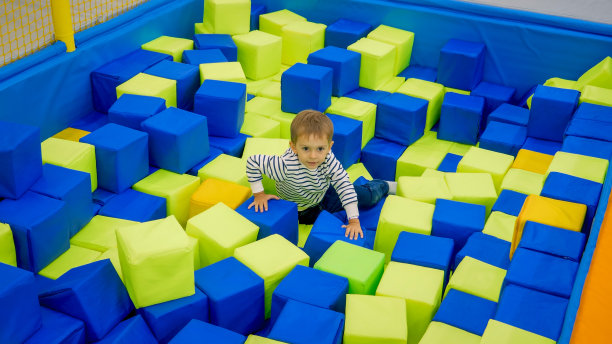 可爱的小男孩在客厅里玩满是软方块的popl图片下载