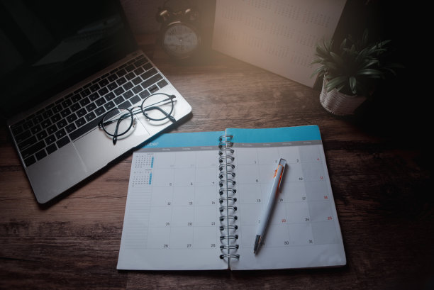 日记和日历的计划管理每日议程，约会，和时间表的工作。笔记本电脑和眼镜放在办公桌上。在家工作概念。图片下载