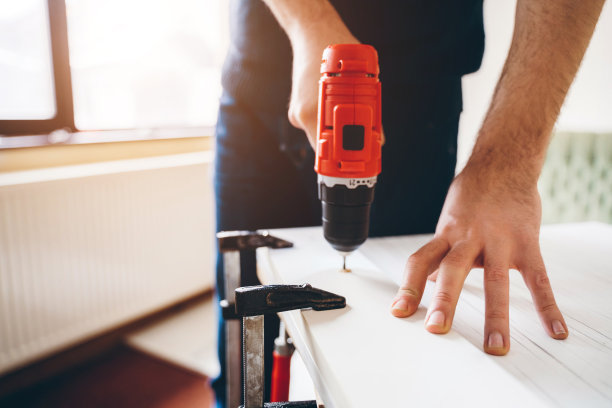 一个用电动螺丝刀工作的手工工人图片下载