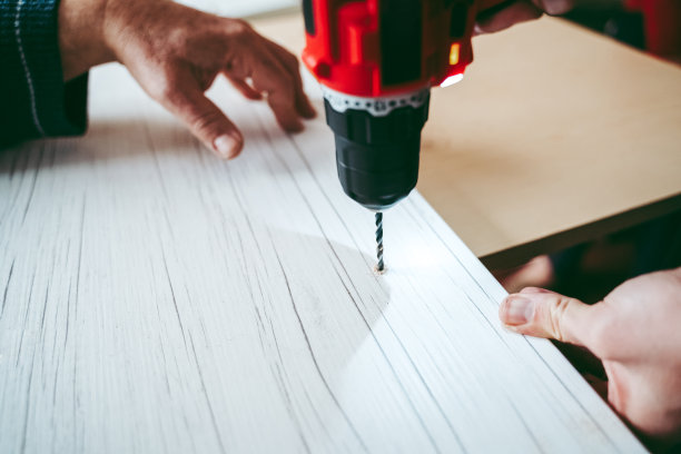 一个用电动螺丝刀工作的手工工人图片下载