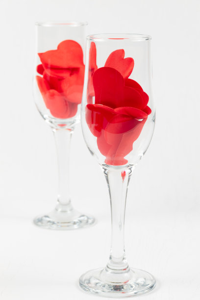 白色木桌上放着两只红桃香槟杯。特写镜头图片下载