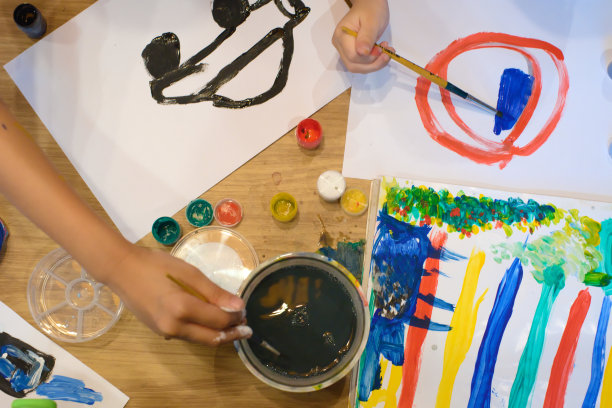 一个亚洲女孩正在白纸上画丙烯。图片下载