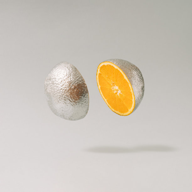 切成银色的金属橙色水果映衬着灰色的背景。图片下载