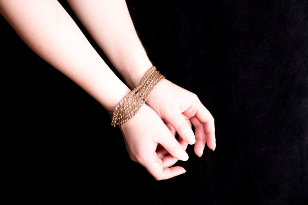 女人们的双手被金色的链子绑着，生活在一个金笼子里，东方的妻子，黑色的背景图片下载