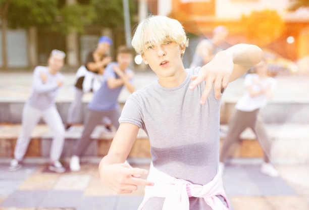 自信的少年街头舞者与团体表演图片下载