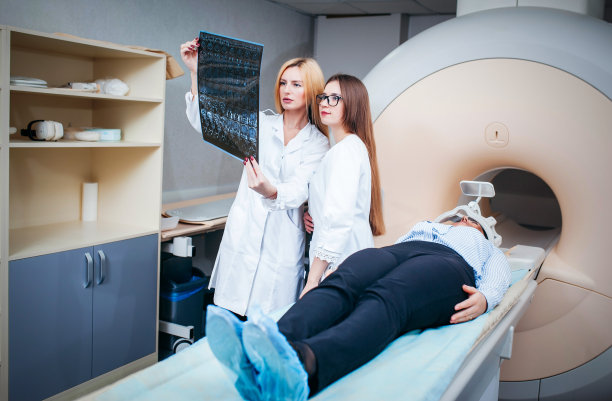 两名女模特医生检查病人，并在他们的手的照片后，CT扫描测试图片下载