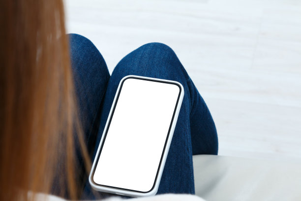 年轻女子的后视图看手机与白色空白屏幕模型。数码科技的生活理念。图片下载