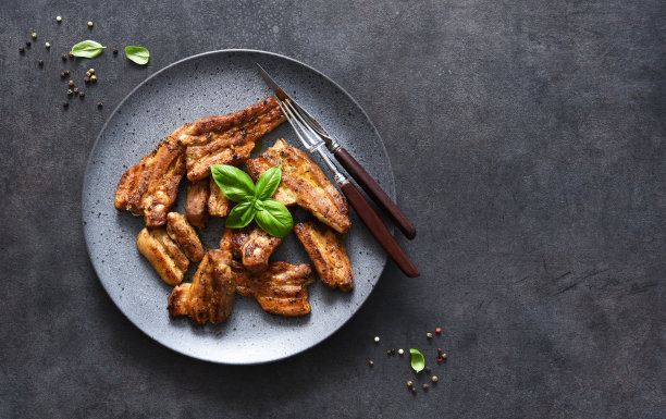 烤排骨装在一个大盘子里，放在石黑色的桌子上。野餐。烧烤。从以上观点。图片下载