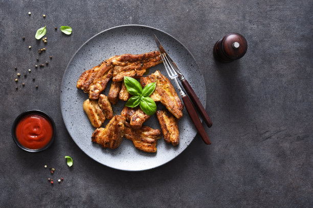 烤排骨装在一个大盘子里，放在石黑色的桌子上。野餐。烧烤。从以上观点。图片下载